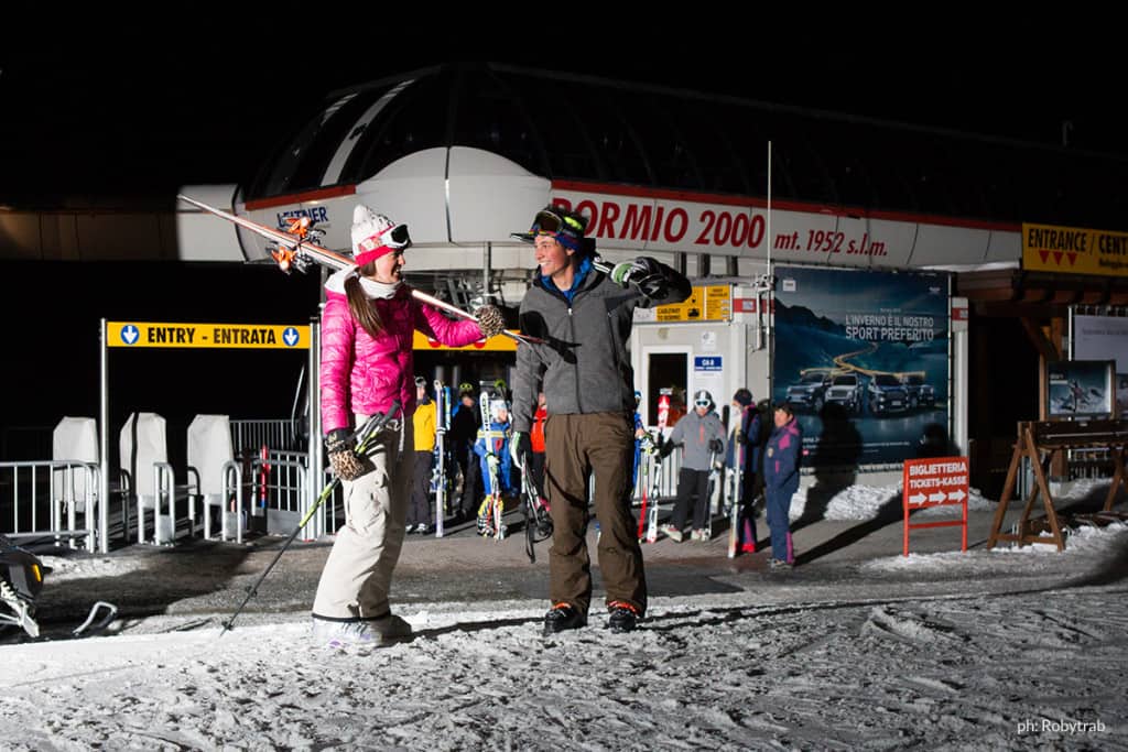 sci notturno: festa in maschera sulla pista Stelvio di Bormio. Coppia di sciatori notturni a Bormio 2000
