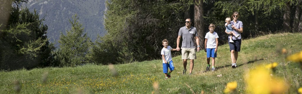 Una famiglia che passeggia con i figli sulle montagne di Bormio.