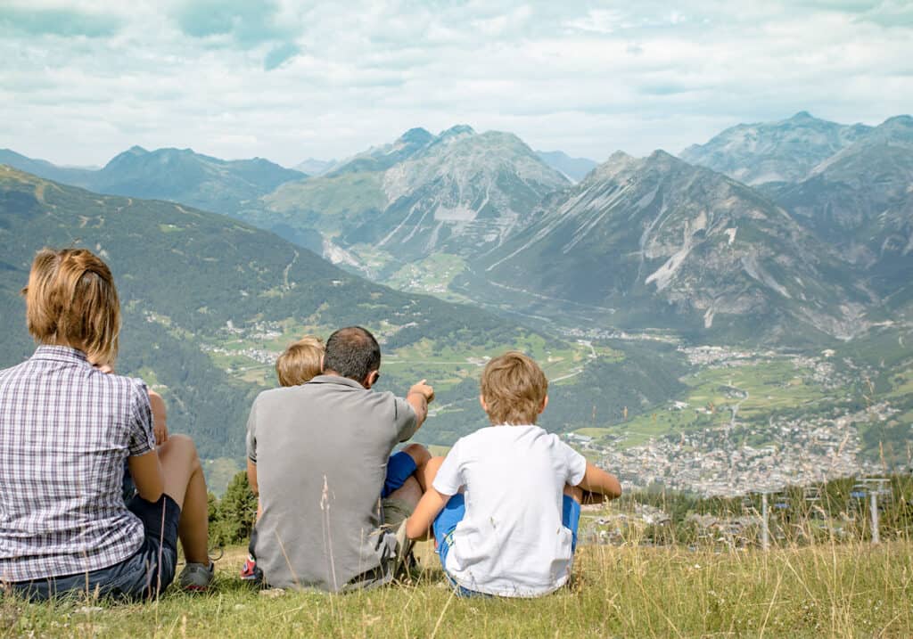 Una famiglia con bambini ammira la vista sulla vallata in montagna.