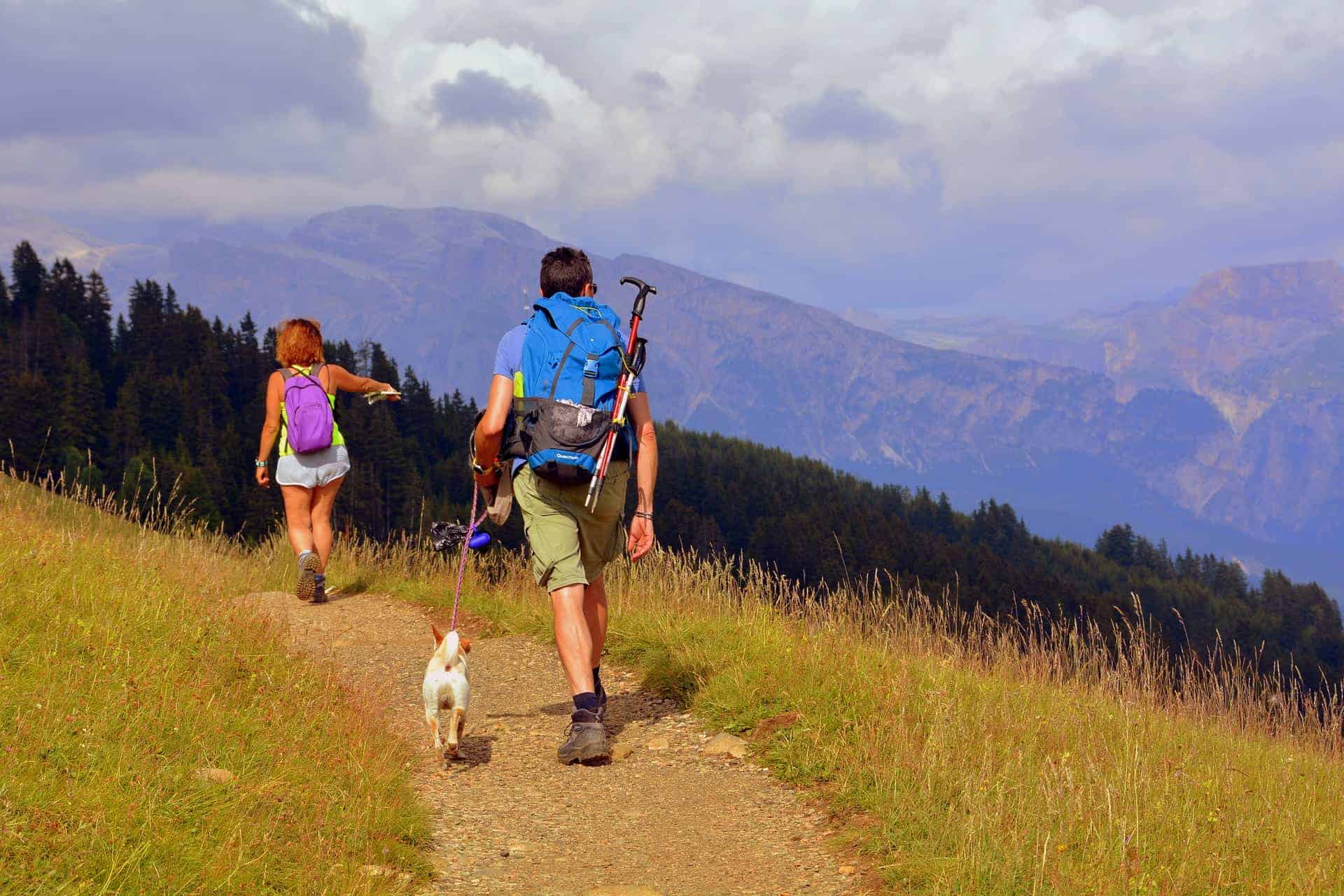 Una coppia cammina sulle montagne della Lombardia insieme al proprio cane