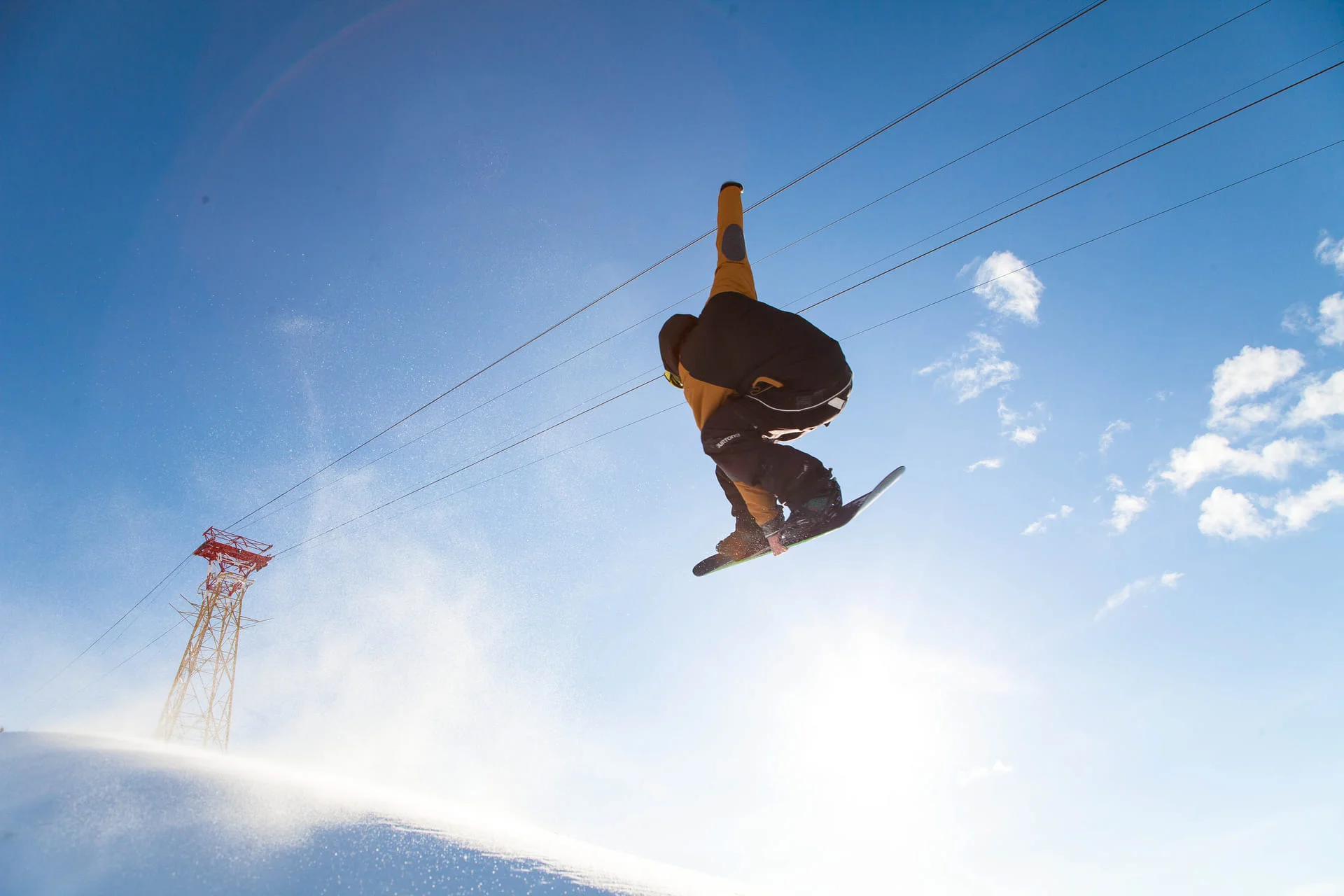 Uno snowboarder si allena eseguendo un'acrobazia in aria.