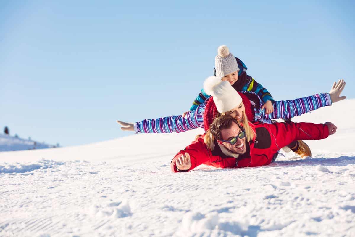 una famiglia si diverte nella neve sulle alpi lombarde
