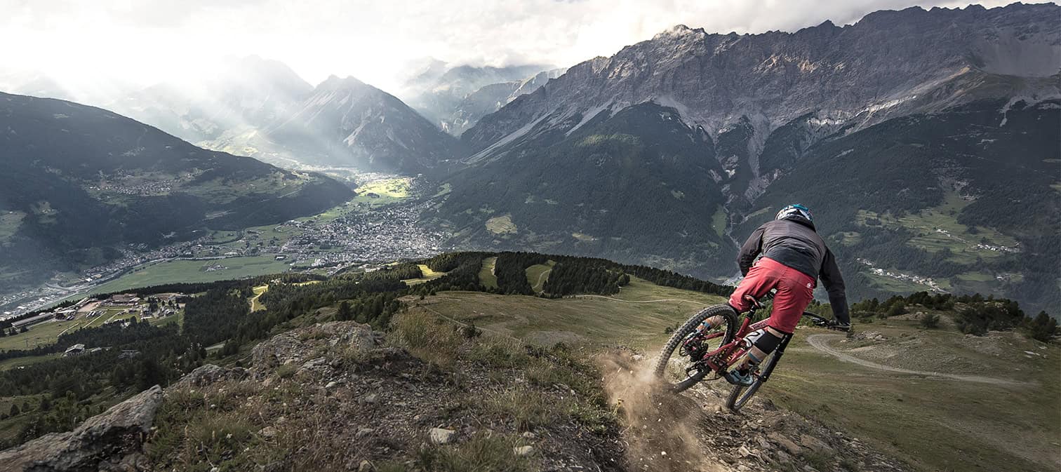 rider downhill in azione: vista su bormio dal bike park